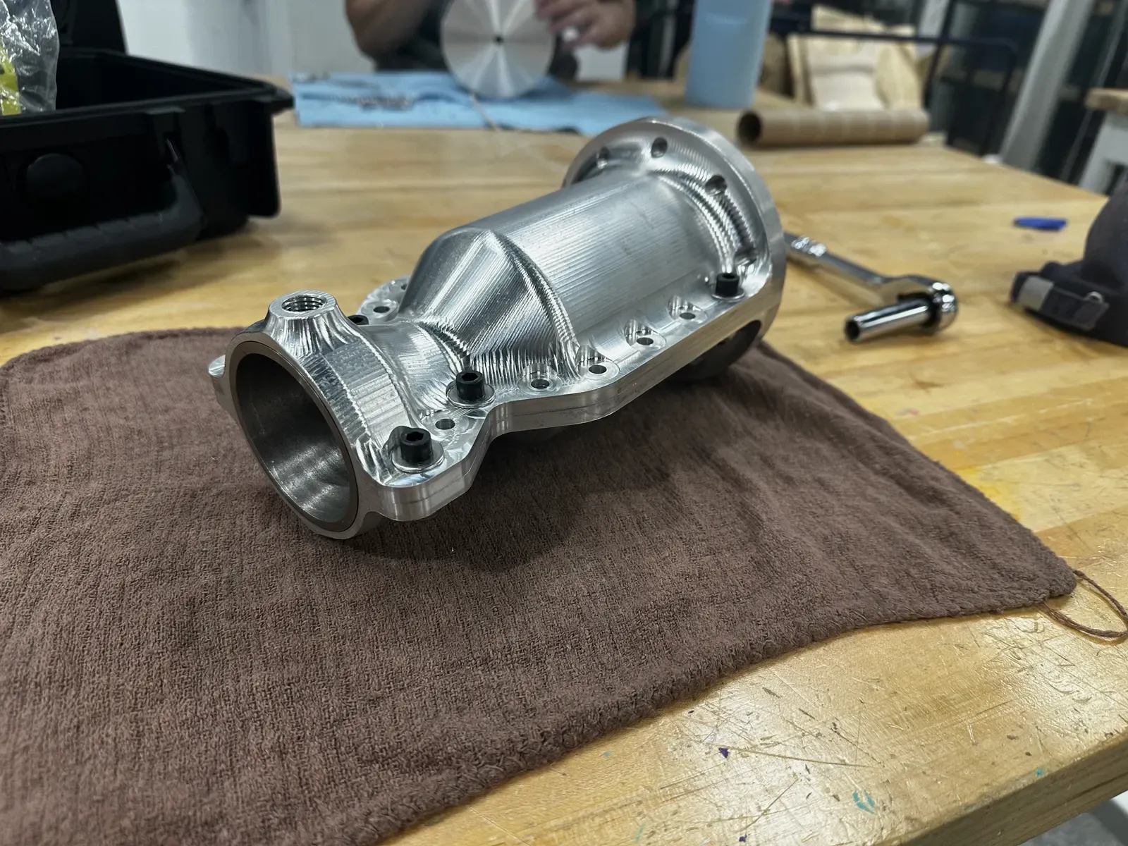 The assembled clamshell engine resting on a workbench, bolt holes running the length of the flange where its two machined halves meet.