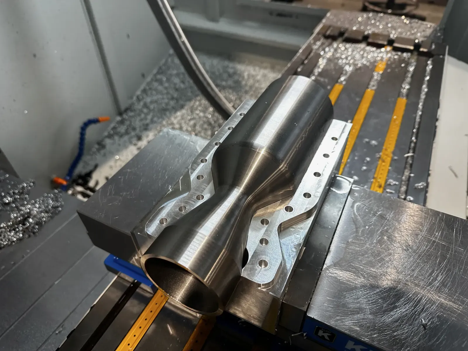 One half of the clamshell engine held in a CNC mill, mid-machining.