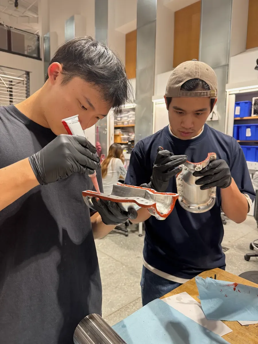 Team members inspecting the two opened clamshell halves.